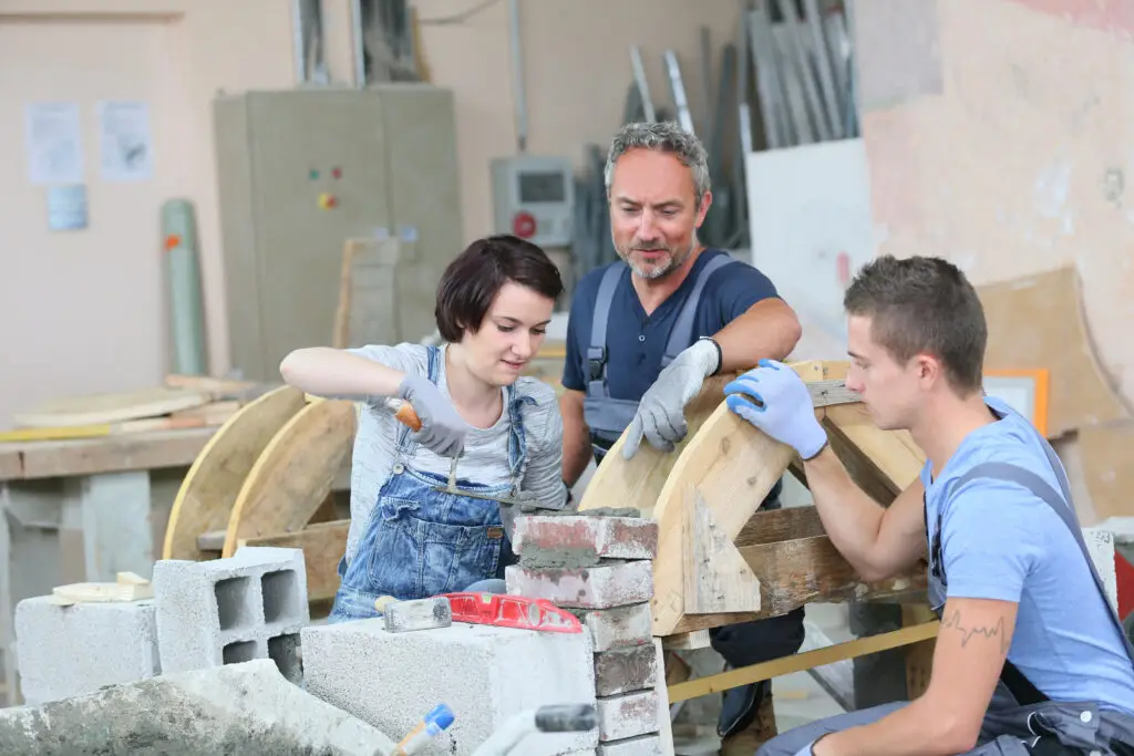 Instructor teaching teenagers brick laying