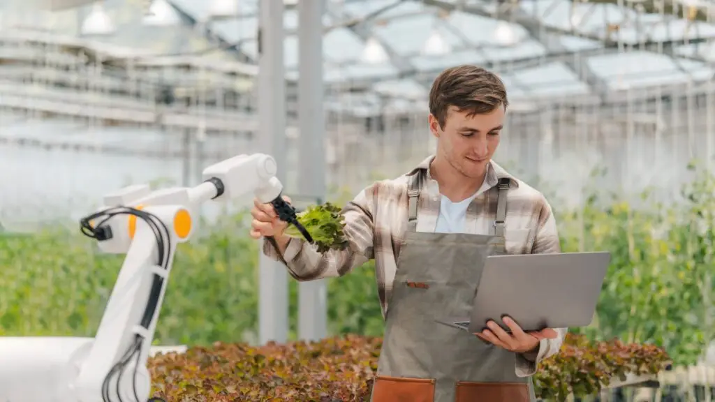 Male,Farmer,Using,Laptop,In,Greenhouse,To,Check,The,Operation